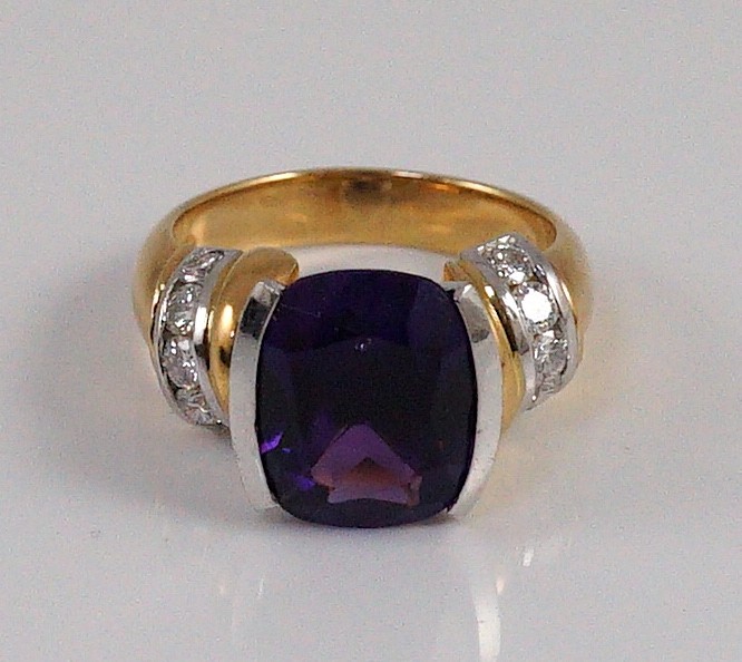 A modern 18ct gold and single stone cushion cut amethyst set dress ring, with ten stone diamond set shoulders